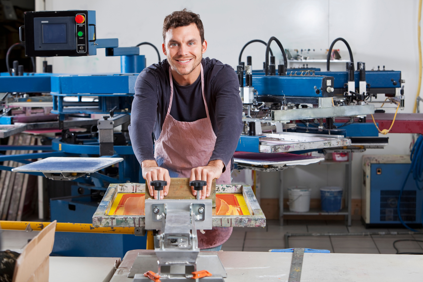 Man operating screen printing equipment